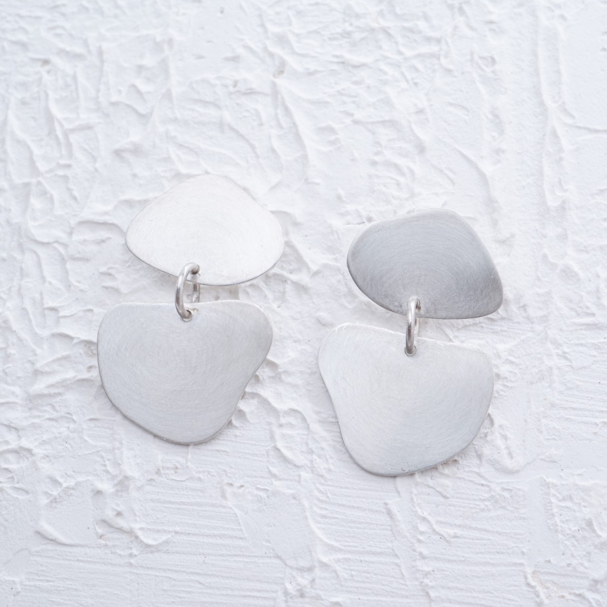 Diese unregelmäßigen Ohrringe aus echtem 925er Sterling Silber sind handgefertigte Unikate. Die organische, moderne Form macht jedes Paar einzigartig und verleiht dem Design einen individuellen Charakter.

Zeitloser Silberschmuck für den Alltag oder als