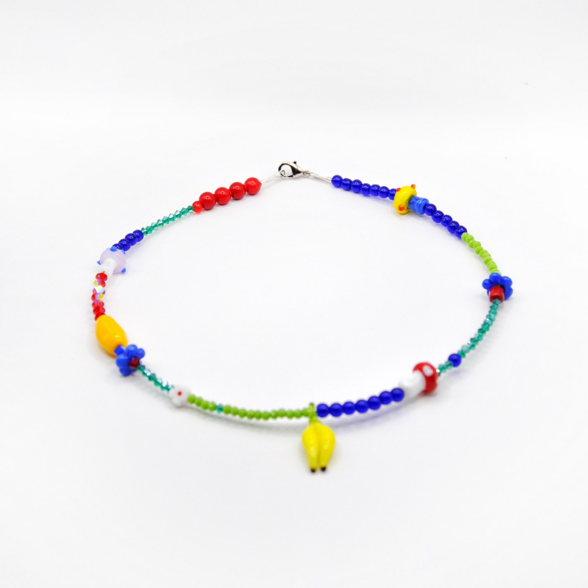 Kette mit Edelsteinen, Glaspilzen, Blumen und Glasbanane von PINAPINA