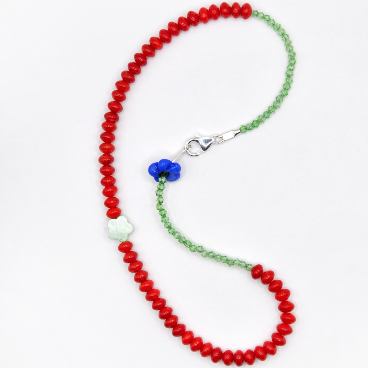 »Blumengarten« – Kette aus roten Edelsteinen und zweierlei Blüten: eine schimmernde Perlmuttblume in der Mitte und eine blaue Glasblüte an der Seite von pinapina