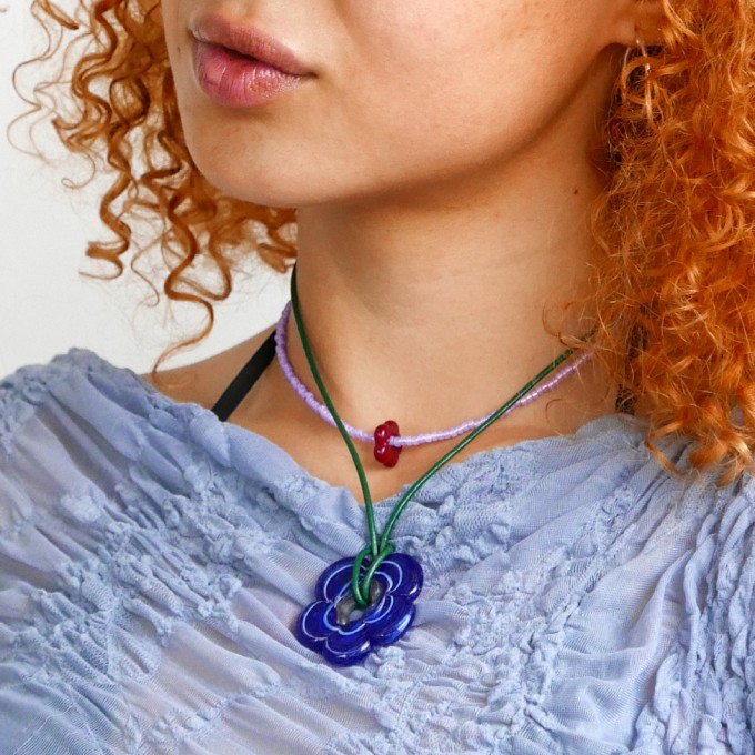 »BloomingAura« – Kette mit rotem Blumenanhänger und violetten Perlen von pinapina
»BloomingAura« – Kette mit rotem Blumenanhänger und violetten Perlen von pinapina